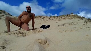 guy fucks  himself on the beach with a  wooden dildo