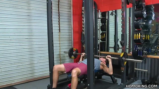 Coach helps on a enormous cocked guy in the gym