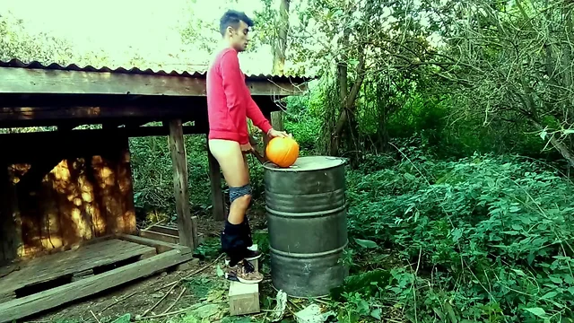 Teenager is hard banging a pumpkin in the garden