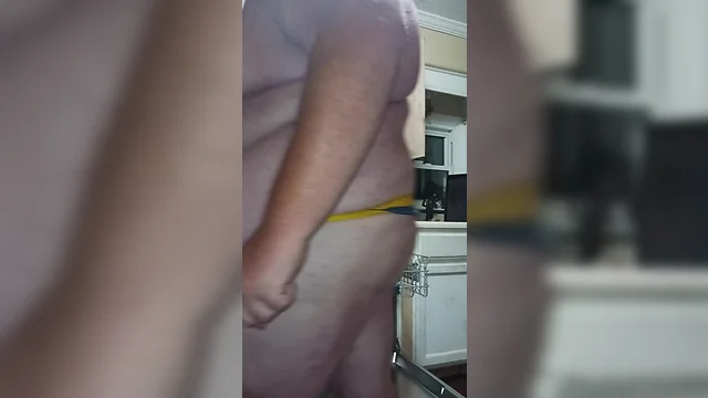 Big man doing household chores in a thong